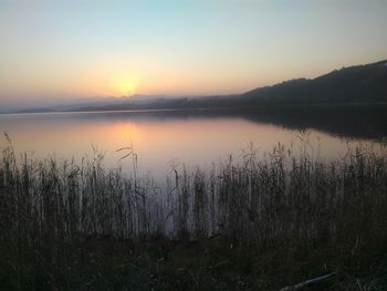 Scenic view of lake against sky during sunset