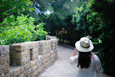 Rear view of woman wearing hat against trees
