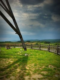 Scenic view of field and bridge against sky