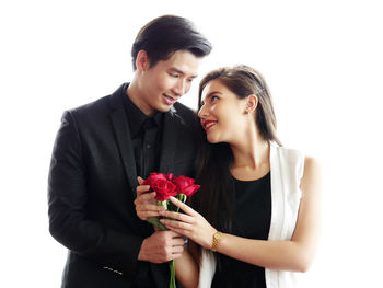 Young couple kissing against white background