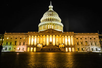Illuminated building against sky at night
