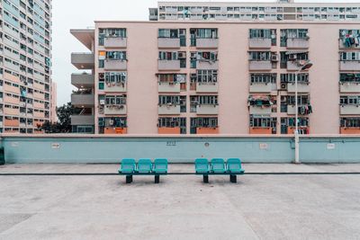 Chairs on street against buildings in city