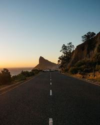 Road by mountain against clear sky