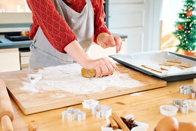 Woman's hands kneading dough with her hands for christmas gingerbread cookies.