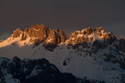 Low angle view of snowcapped mountains against sky