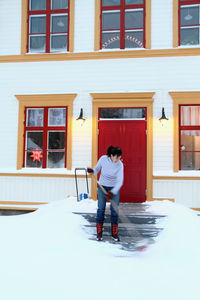 Woman removing snow from front steps