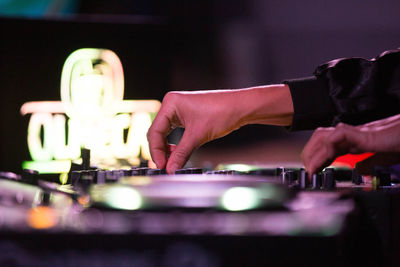 Cropped hand of musician adjusting audio equipment