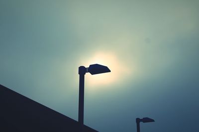 Low angle view of silhouette street lights against sky