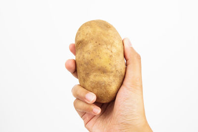 Close-up of hand holding ice cream over white background