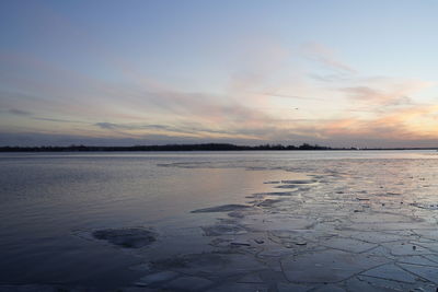 Scenic view of frozen lake against sky during sunset