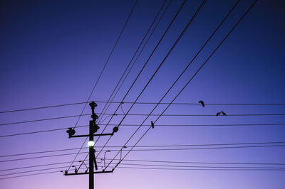 Low angle view of power lines against clear blue sky