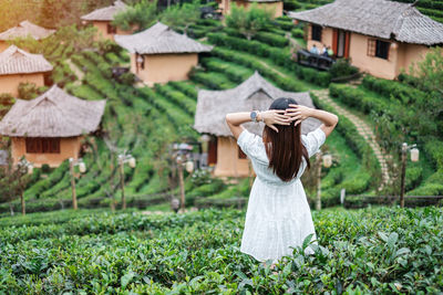 Rear view of woman standing by plants