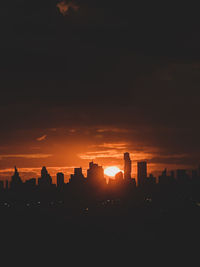 Silhouette buildings against sky during sunset