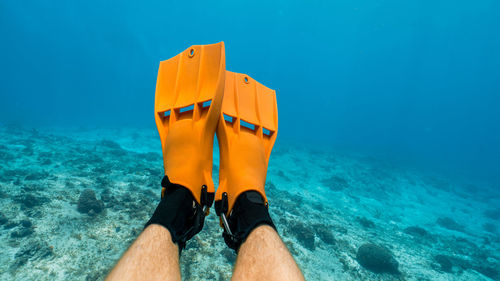 Using orange fins to scuba dive in cozumel, mexico