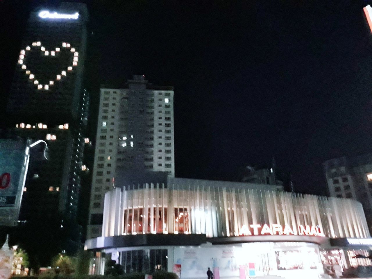 LOW ANGLE VIEW OF ILLUMINATED CITY AGAINST SKY