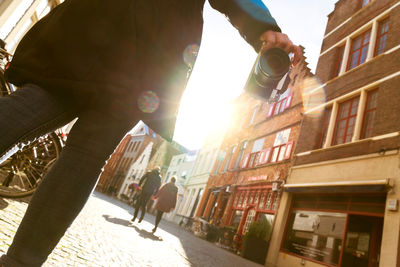 Woman walking on street amidst buildings in city