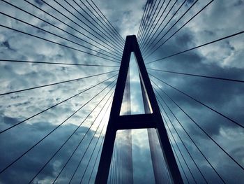 Low angle view of suspension bridge against sky