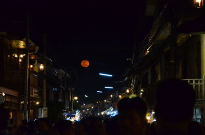 People walking in illuminated city at night