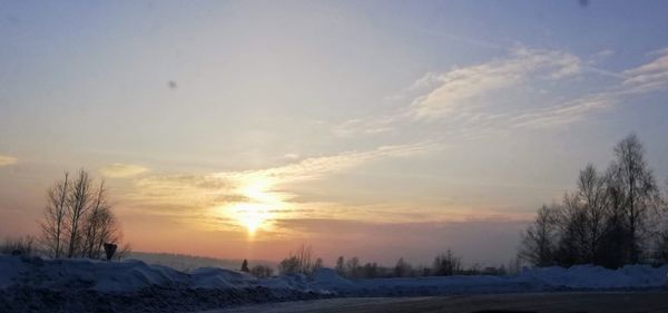 Scenic view of snow field against sky during sunset