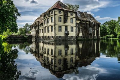 Reflection of buildings on lake against sky