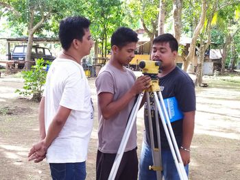 Young man standing on bottle against trees
