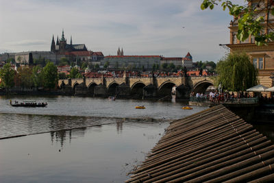 Bridge over river against buildings in city