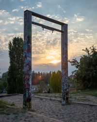 Abandoned built structure on field against sky during sunset