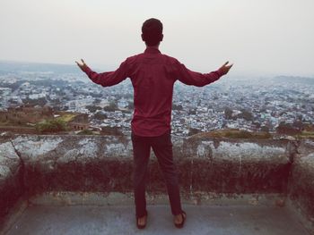 Rear view of man looking at cityscape