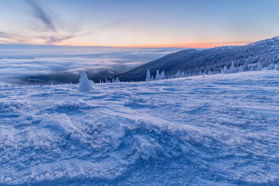 Scenic view of frozen lake against sky during sunset