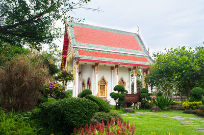 Traditional building by trees against sky