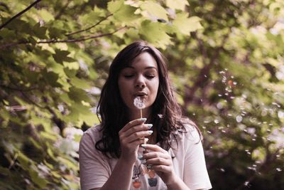 Portrait of young woman holding plant