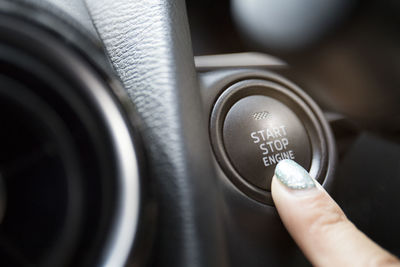 Close-up of woman pushing button in car