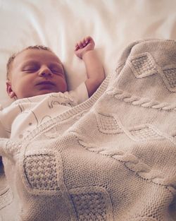 Blond baby sleeping on bed