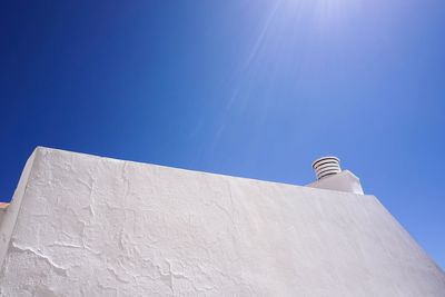 Low angle view of white building against clear blue sky