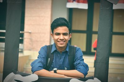 Portrait of smiling young man sitting outdoors