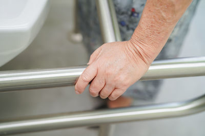 Close-up of hand holding metal railing