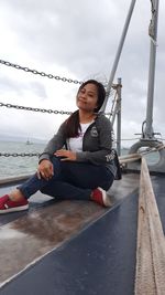 Low angle view of young man sitting on boat