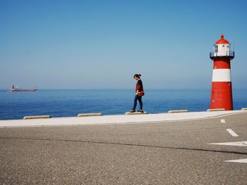 Man standing on sea against clear sky