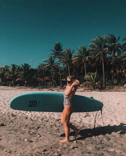 Full length of woman standing on beach against sky