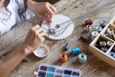 High angle view of woman stitching on table