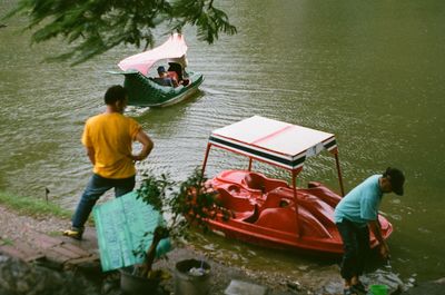 People standing on boat in lake