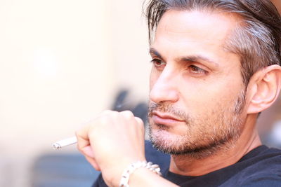 Close-up of man looking away while smoking cigarette