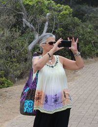 Woman photographing with text on tree