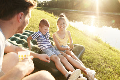 Rear view of friends sitting on grass at park