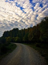 Empty road against cloudy sky