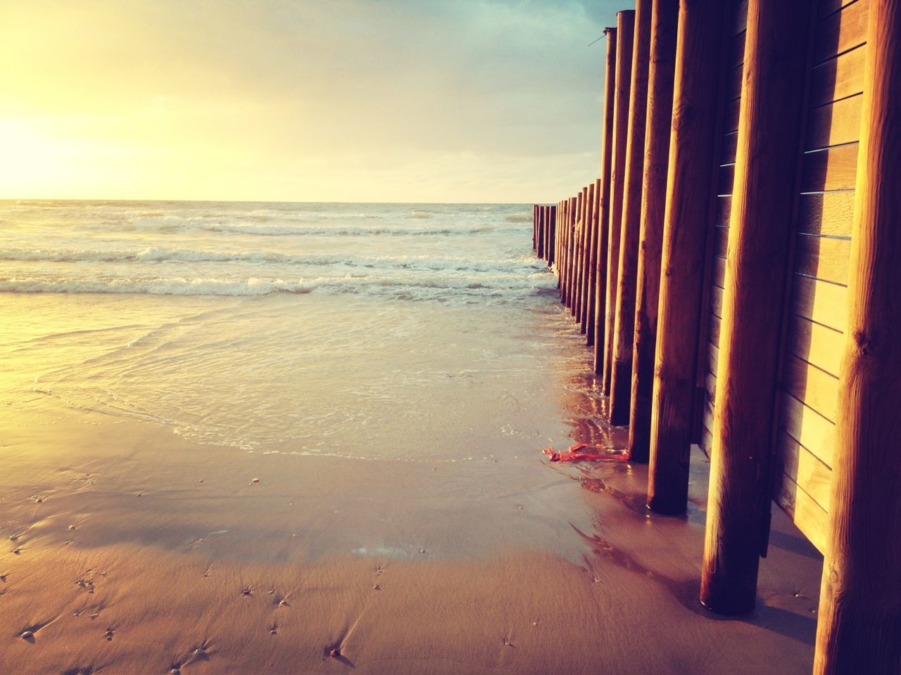 sea, beach, water, horizon over water, sand, sky, shore, built structure, architecture, wave, scenics, surf, tranquility, beauty in nature, nature, sunset, tranquil scene, cloud - sky, coastline, pier