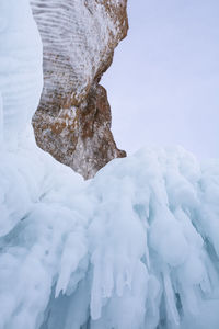 Frozen rocks against sky