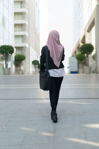 Rear view of young woman walking on street