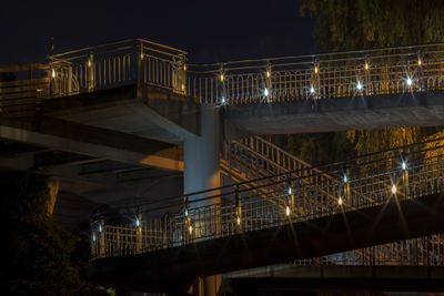 Low angle view of illuminated footbridge at night