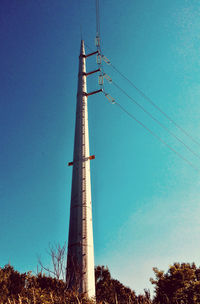 Low angle view of communications tower against clear blue sky